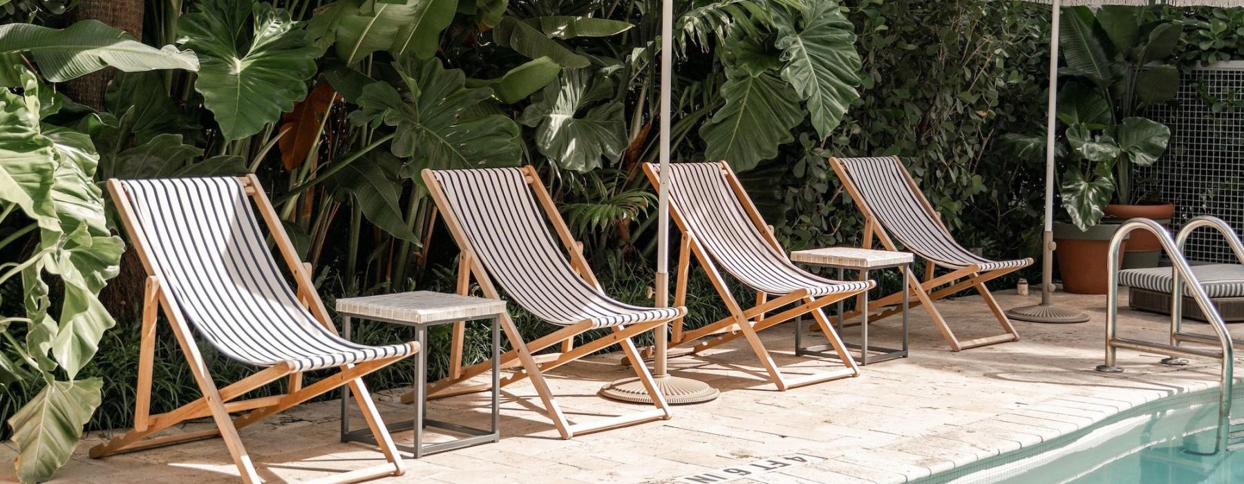 a pool with chairs and umbrellas by it