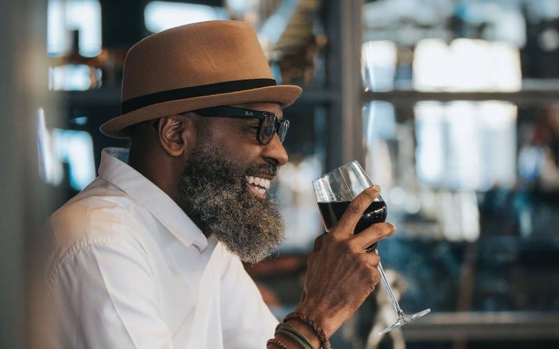 man sitting with a glass of wine in his hand