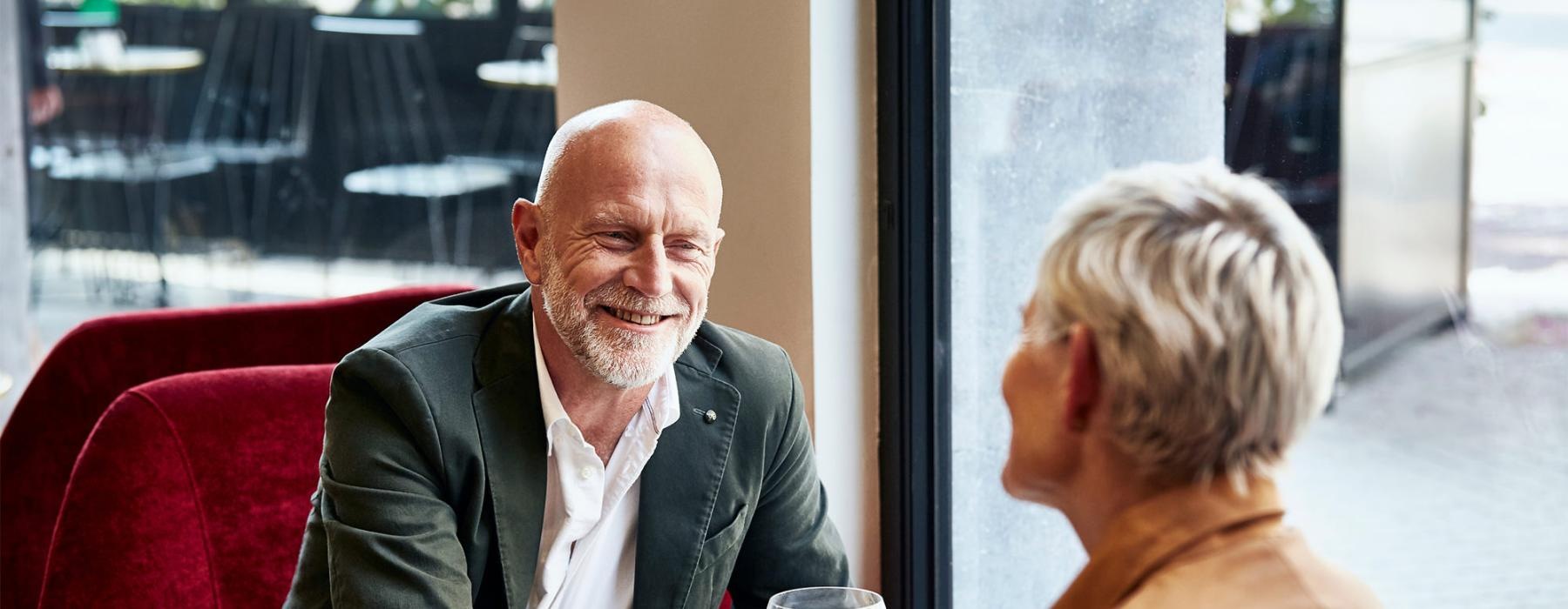 a man and a woman sitting at a table with cocktails